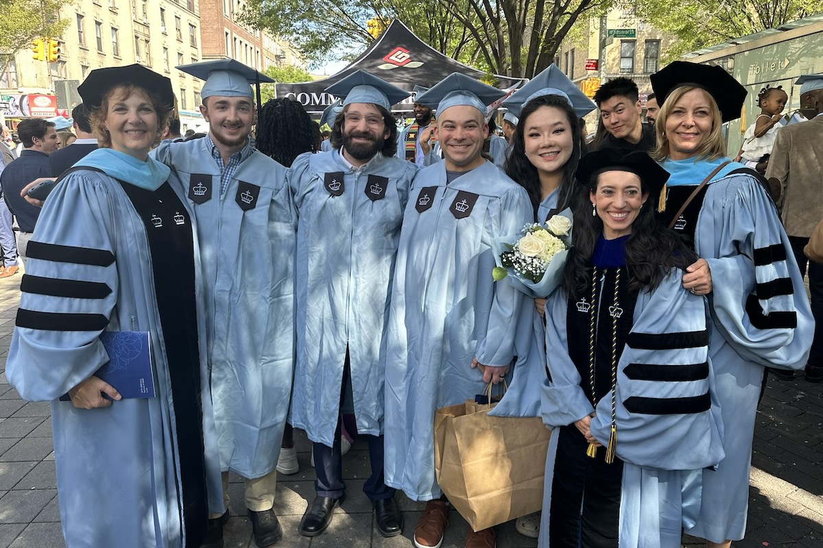 Graduates taking a group photo with Professor Quinn at TC Convocation.